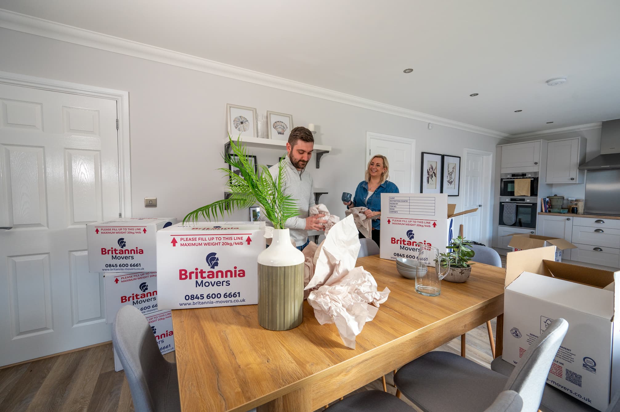 Two people packing a kitchen ready for a house removal